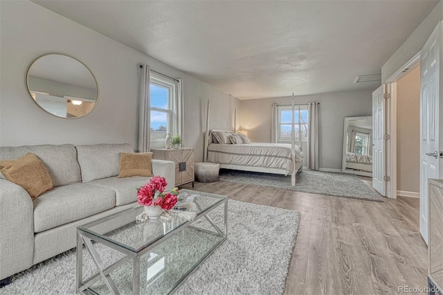 bedroom with baseboards and wood finished floors