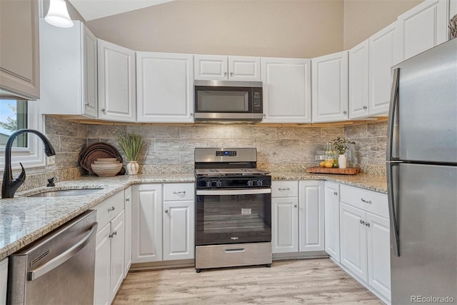 kitchen with a sink, white cabinets, and stainless steel appliances