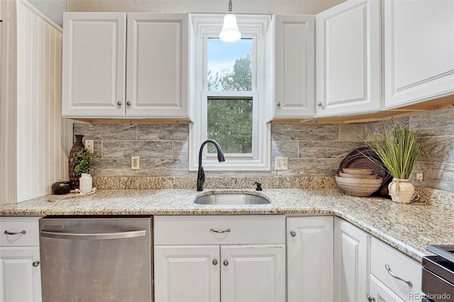 kitchen with stainless steel dishwasher, white cabinetry, light stone counters, and a sink