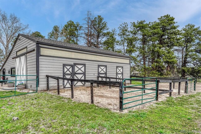 view of outdoor structure with an exterior structure, fence, and an outbuilding