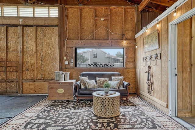 sitting room with vaulted ceiling and wood walls
