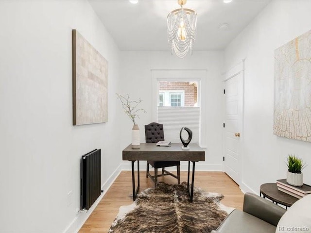 home office featuring radiator heating unit, light wood-type flooring, and baseboards