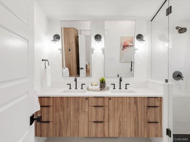 bathroom with a sink, double vanity, and a shower stall