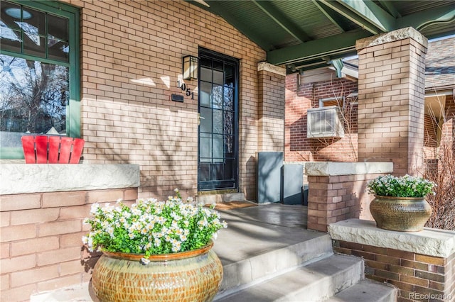 property entrance with brick siding and covered porch