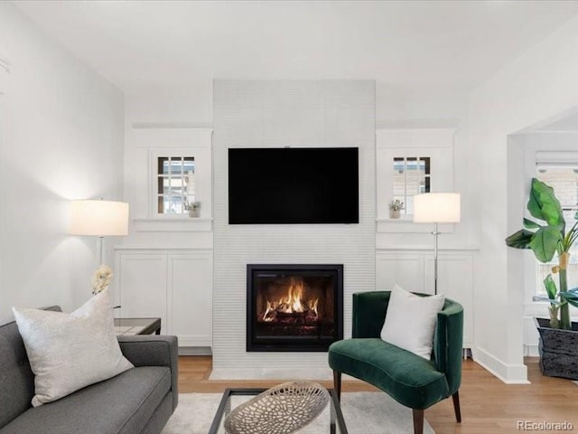 living room with plenty of natural light, a fireplace, and wood finished floors