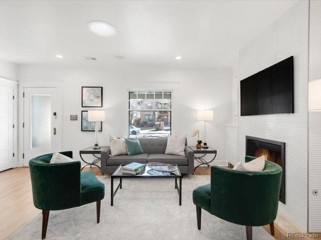 living room featuring recessed lighting, visible vents, wood finished floors, and a fireplace