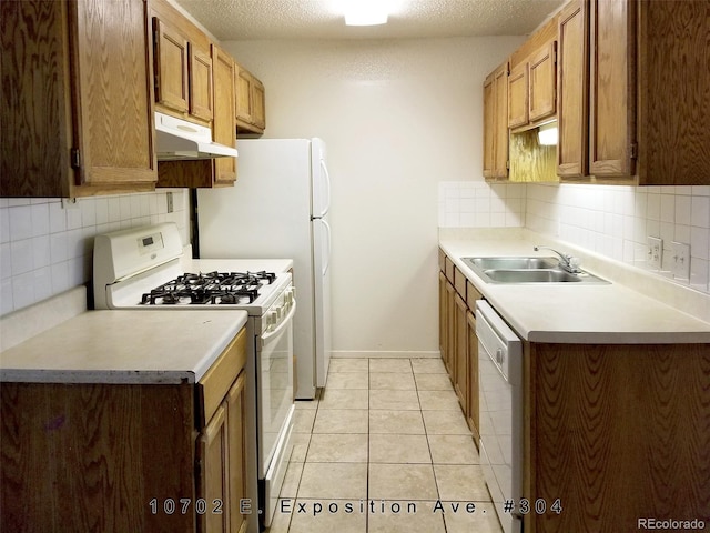 kitchen with light tile floors, a textured ceiling, sink, white appliances, and tasteful backsplash