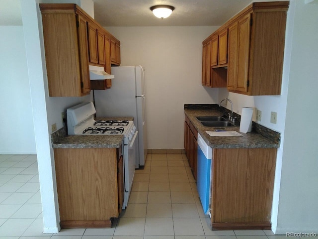 kitchen featuring white appliances, sink, and light tile flooring