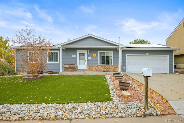 ranch-style house featuring a garage, a front yard, stone siding, and driveway