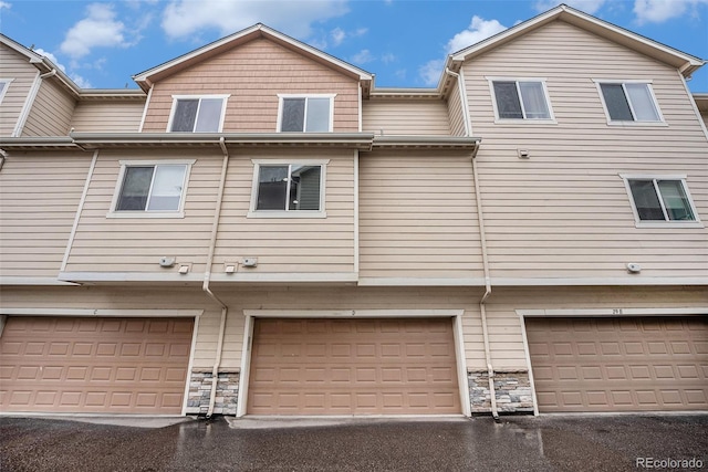 11250 Florence St Unit 29D, Commerce City, CO 80640 - back of property with stone siding and a garage