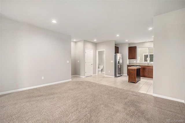11250 Florence St Unit 29D, Commerce City, CO 80640 - unfurnished living room with light carpet, recessed lighting, baseboards, a sink, and light tile patterned floors