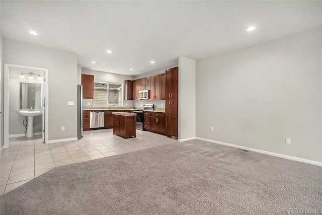 11250 Florence St Unit 29D, Commerce City, CO 80640 - kitchen featuring appliances with stainless steel finishes, a center island, light tile patterned floors, baseboards, and recessed lighting