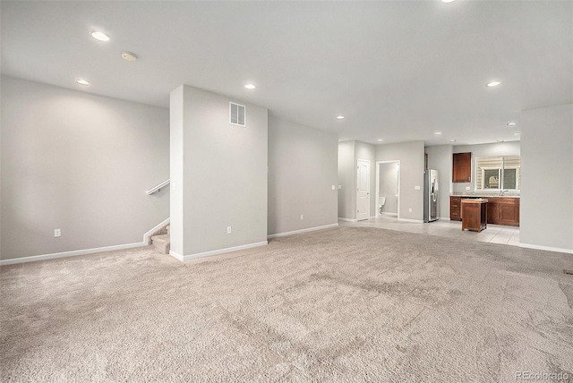 11250 Florence St Unit 29D, Commerce City, CO 80640 - unfurnished living room featuring light carpet, baseboards, stairway, and recessed lighting