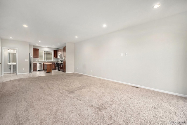 11250 Florence St Unit 29D, Commerce City, CO 80640 - unfurnished living room featuring light colored carpet, baseboards, recessed lighting, and a sink