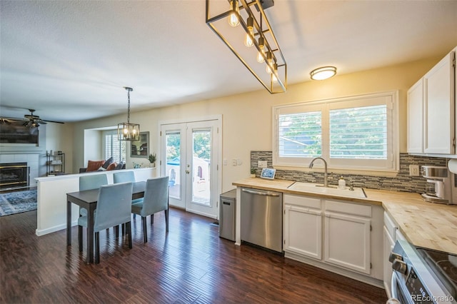 2695 Woodrose Pl, Highlands Ranch, CO 80129 - kitchen featuring stainless steel appliances, a ceiling fan, tasteful backsplash, dark wood-type flooring, and white cabinets
