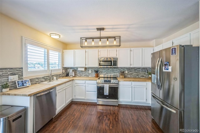 2695 Woodrose Pl, Highlands Ranch, CO 80129 - kitchen with appliances with stainless steel finishes, butcher block counters, white cabinets, tasteful backsplash, and dark wood-style floors