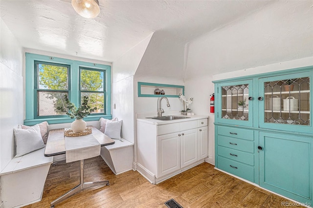 interior space with a sink, light wood finished floors, and visible vents