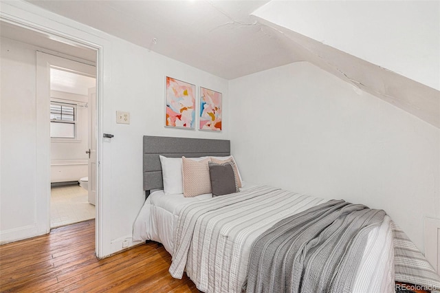 bedroom featuring wood-type flooring and baseboards