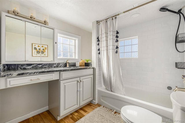 full bathroom featuring toilet, wood-type flooring, vanity, and shower / tub combo with curtain