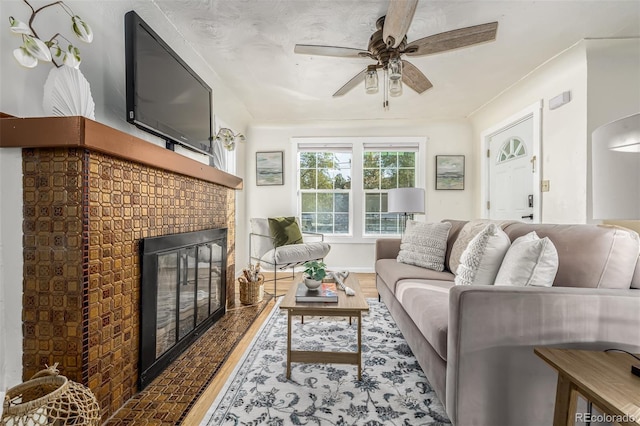 living room with ceiling fan, hardwood / wood-style floors, and a fireplace