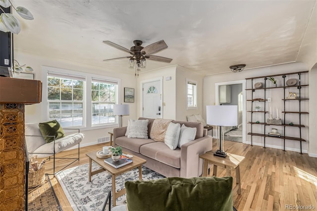 living room featuring ceiling fan and light hardwood / wood-style floors