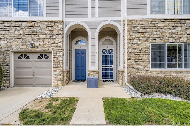 4221 S Blackhawk Cir Unit 7G, Aurora, CO 80014 - doorway to property featuring stone siding, concrete driveway, and an attached garage