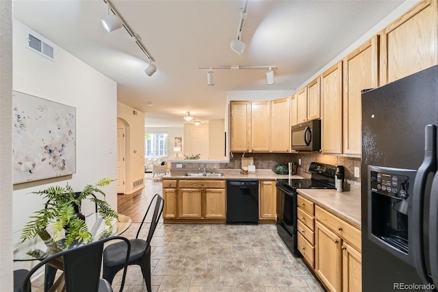 4221 S Blackhawk Cir Unit 7G, Aurora, CO 80014 - kitchen with black appliances, tasteful backsplash, light brown cabinetry, a peninsula, and open floor plan