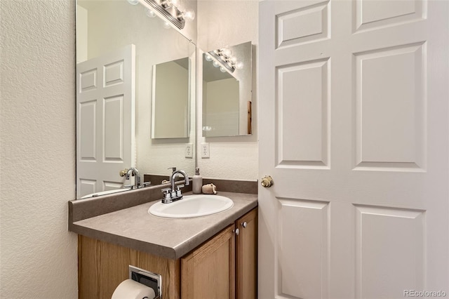 4221 S Blackhawk Cir Unit 7G, Aurora, CO 80014 - bathroom featuring a textured wall and vanity