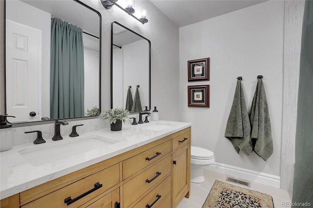 bathroom with tile patterned floors, vanity, and toilet