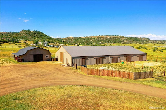 view of front of property with a mountain view and an outdoor structure