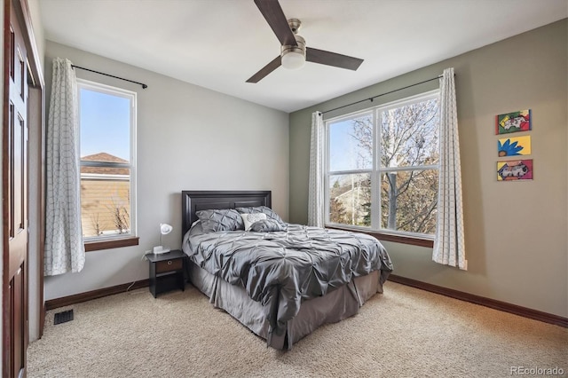 bedroom featuring baseboards, visible vents, a ceiling fan, and light colored carpet