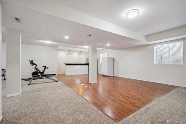 workout area with recessed lighting, wood finished floors, visible vents, and baseboards