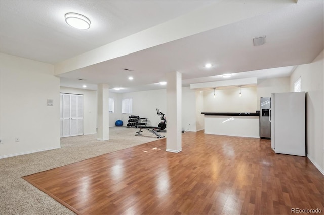 workout room with carpet floors, recessed lighting, wood finished floors, and baseboards