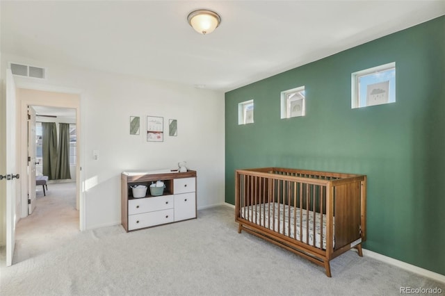 carpeted bedroom featuring a crib