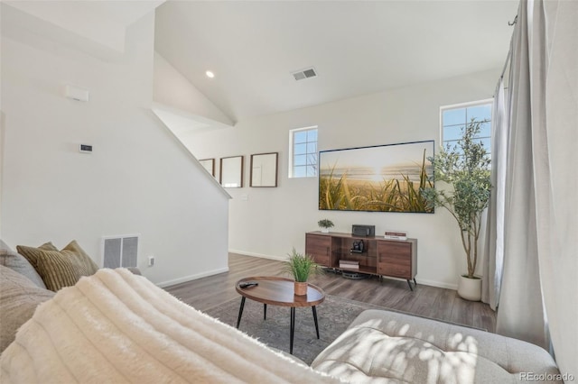 living room featuring plenty of natural light, high vaulted ceiling, and dark hardwood / wood-style flooring