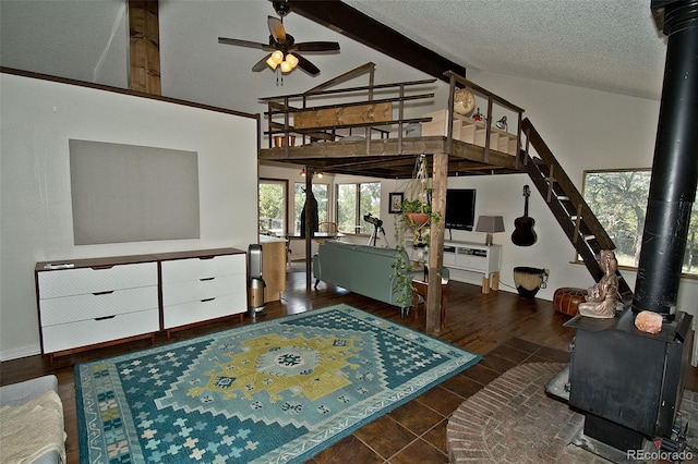 bedroom featuring a textured ceiling, vaulted ceiling with beams, and a wood stove