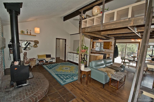 living room featuring a wood stove, a textured ceiling, and lofted ceiling with beams