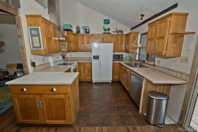 kitchen with a textured ceiling, lofted ceiling, stainless steel appliances, sink, and kitchen peninsula