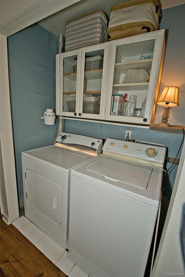 clothes washing area with wood-type flooring and washer and dryer