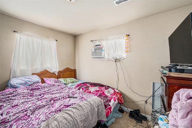 carpeted bedroom featuring visible vents and a textured wall