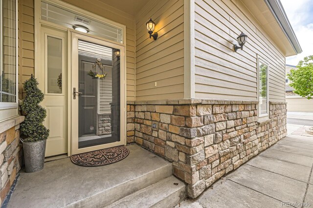 doorway to property featuring stone siding