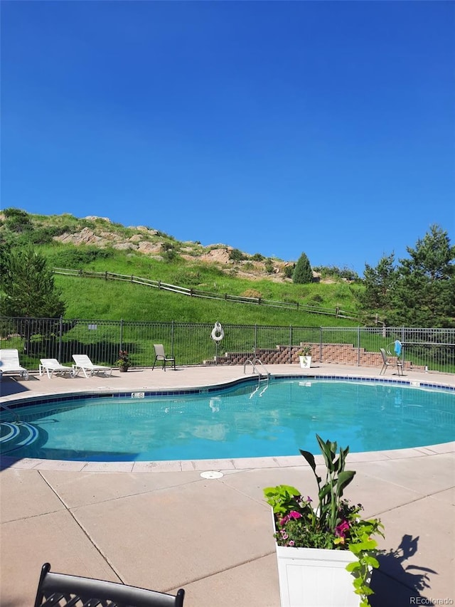 community pool with fence and a patio