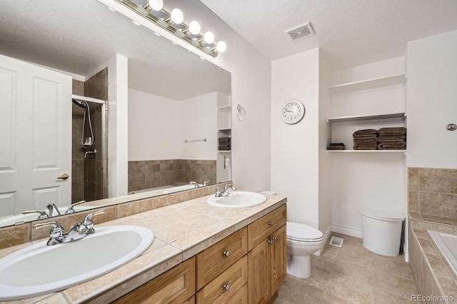 full bathroom with tile patterned floors, tiled tub, a sink, and toilet