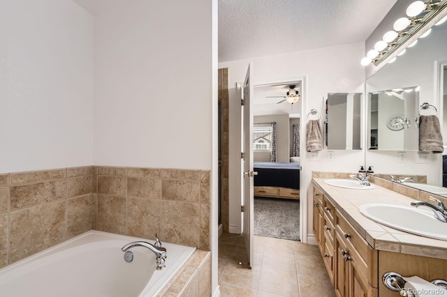 ensuite bathroom with a garden tub, a ceiling fan, a sink, and double vanity