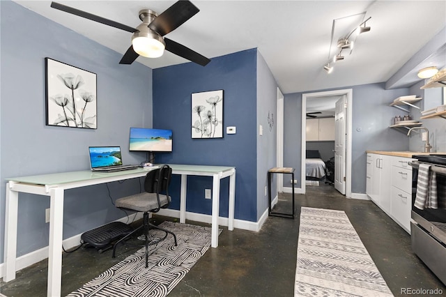 office area with finished concrete floors, baseboards, and a ceiling fan