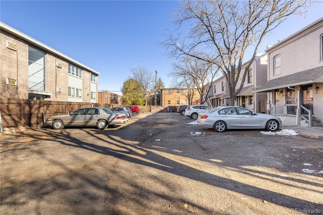 uncovered parking lot with fence and a residential view