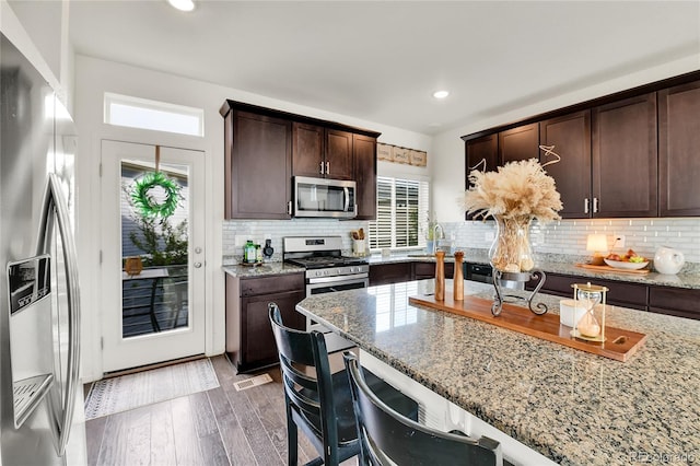 240 S Oak Hill St, Aurora, CO 80018 - kitchen with stainless steel appliances, light stone counters, wood finished floors, dark brown cabinets, and recessed lighting