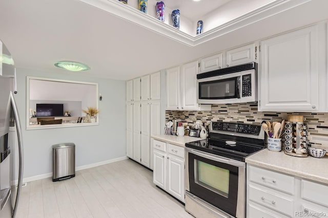 7640 S Monaco Cir W, Centennial, CO 80112 - kitchen featuring stainless steel appliances, light countertops, tasteful backsplash, and white cabinetry