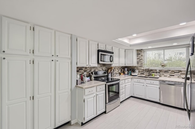7640 S Monaco Cir W, Centennial, CO 80112 - kitchen with appliances with stainless steel finishes, backsplash, light countertops, white cabinets, and recessed lighting