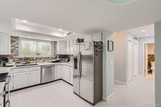 7640 S Monaco Cir W, Centennial, CO 80112 - kitchen featuring stainless steel appliances, backsplash, a tray ceiling, light countertops, and recessed lighting